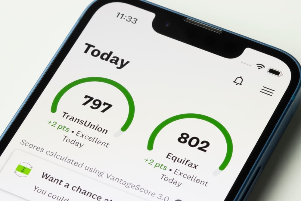 Smartphone displaying credit scores: 797 for TransUnion, 802 for Equifax, both excellent.