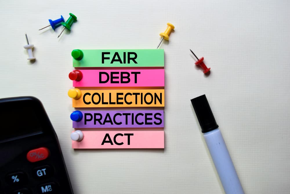 Fair Debt Collection Practices Act - FDCPA text on sticky notes placed on an office desk