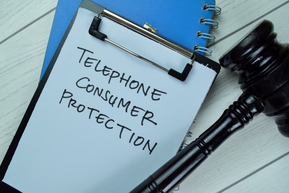 Clipboard with "Telephone Consumer Protection" written on it, alongside a gavel, symbolizing legal advocacy assistance.