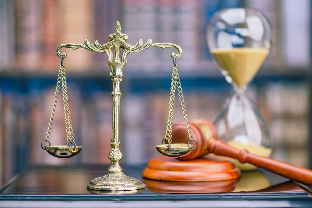 A scale of justice, gavel, and hourglass represent legal actions against telemarketers under TCPA.